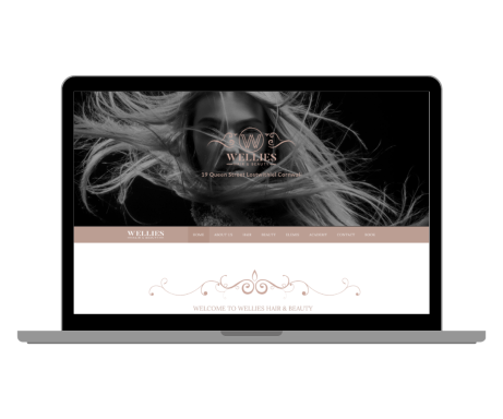 Wellies Haie And Beauty Website By Rocket Media Services A stylish laptop displaying a black-and-white portrait with flowing hair.